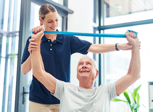 A physical therapist helping a man exercise